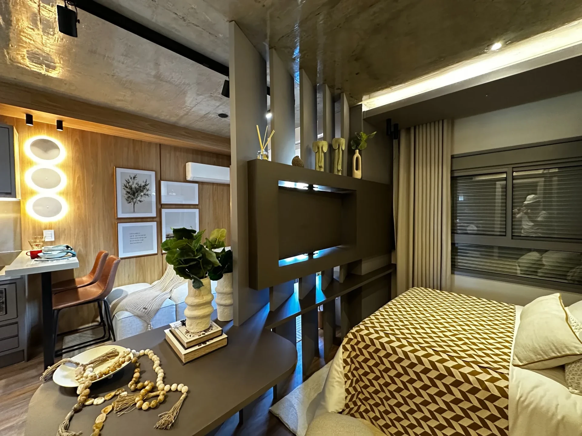 Ambiente do studio decorado com divisória marcenaria entre estar e dormitório