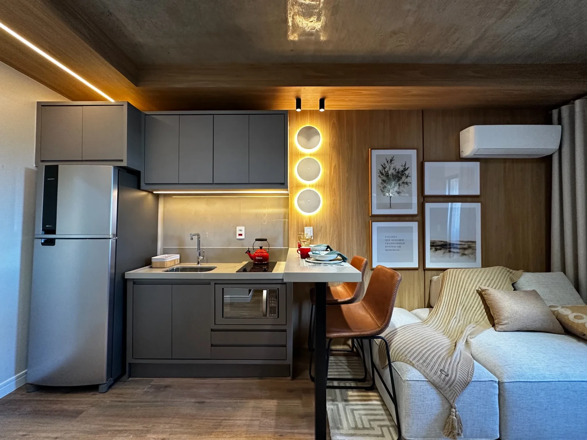 Cozinha compacta do studio decorado com bancada, cooktop e marcenaria planejada