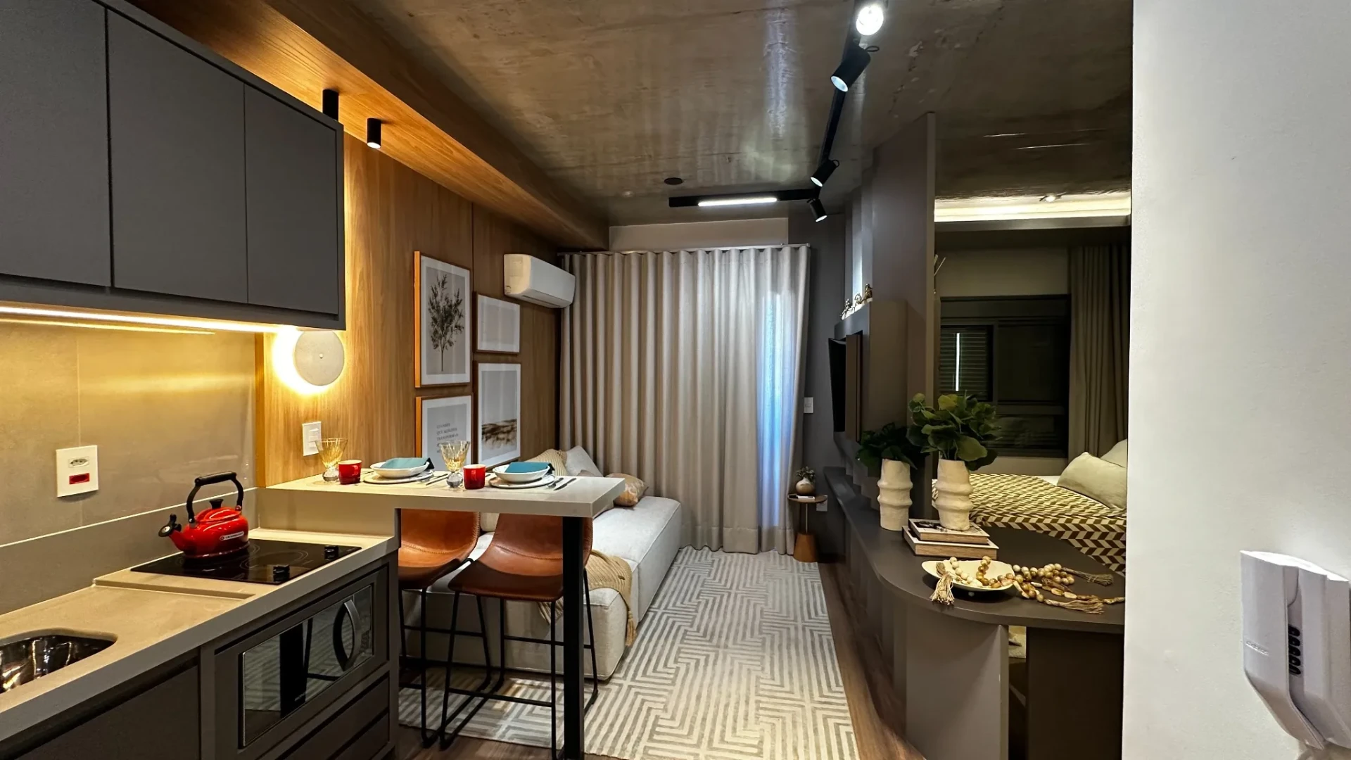 Perspectiva da cozinha para o estar e dormitório do studio decorado
